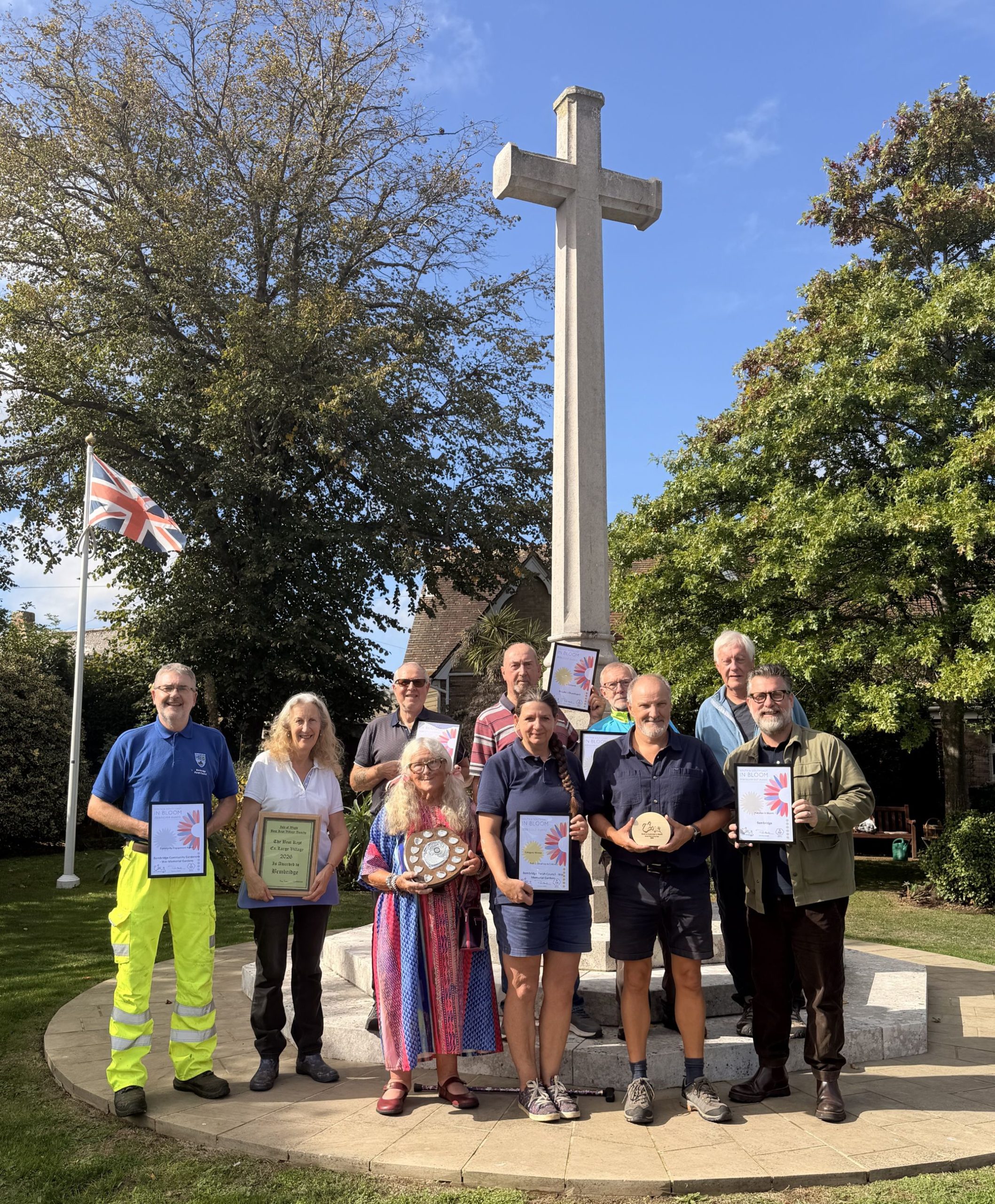 Bembridge Council reps stand with awards in front of a memorial